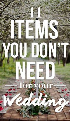 a wooden table topped with lots of plates and glasses filled with red flowers on top of it