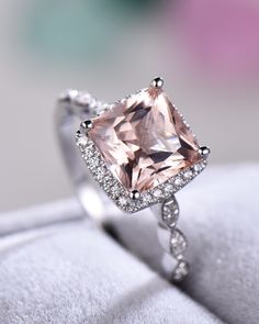 an engagement ring with a pink diamond in the center and diamonds on it's sides