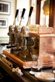 an espresso machine sitting on top of a counter next to other coffee machines