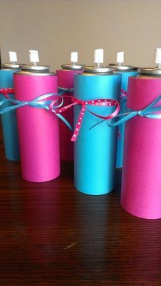 six pink and blue cans wrapped in twine, tied with a ribbon on a wooden table