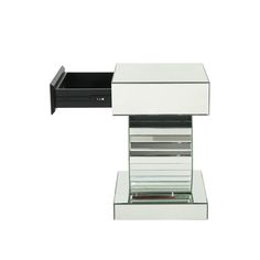 a white and black desk with drawers on the top, one drawer open to reveal a magazine holder