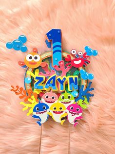 a number one cake topper surrounded by cutouts of fish and under the sea creatures