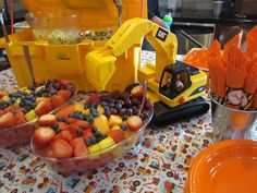 a table topped with bowls filled with fruit and veggies next to orange plates