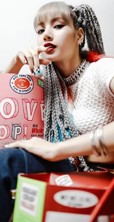 a woman sitting on top of a red chair holding a pink bag with her hand