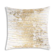 a gold and white pillow on a white background