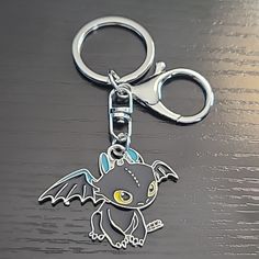 a metal keychain with an image of a dragon on it's side