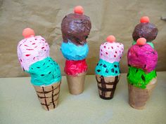 four ice cream cones with different toppings on them, all decorated in various colors