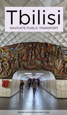 people walking through a tunnel with the words tbilisi above it and below them