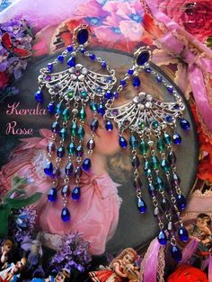 "These Colorful Ombre Crystal Peacock Chandelier Earrings are made with sparkling shades of crystal beads: Tanzanite Purple, Amethyst, Cobalt Blue, Teal and Emerald with sweet little brass flower embellishments.  The peacock fan filigrees are decorated with 7 sparkling rainbow shades of crystal rhinestones!  Available with Posts, Clip-Ons or French Wires. -6\" Long x 2\" Wide -0.5 oz. ea. -Can be shortened upon request Metal Finishes Available: -Bronze (2'nd & 3'rd images-and video) -Silver (1's Bohemian Crystal Earrings For Party, Bohemian Jeweled Crystal Earrings For Party, Beaded Teardrop Chandelier Earrings For Party, Crystal Beaded Earrings For Party, Glamorous Blue Chandelier Drop Earrings, Glamorous Blue Chandelier Earrings, Bohemian Peacock Design Earrings For Party, Bohemian Crystal Chandelier Drop Earrings, Bohemian Crystal Chandelier Earrings