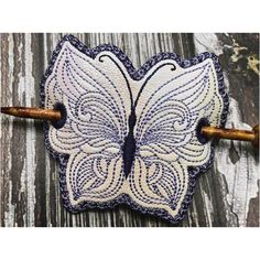 a white and purple butterfly on a wooden surface with an arrow in the middle,