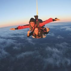 two people are skydiving over the earth