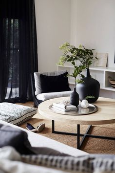 a living room filled with furniture and a potted plant on top of a table