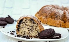 an oreo cookie bundt cake on a white plate with chocolate chips around it