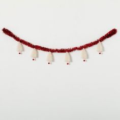 a red and white string with tassels hanging from it's end on a white wall