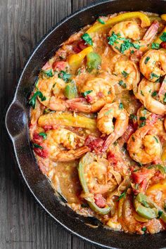 a skillet filled with shrimp and vegetables