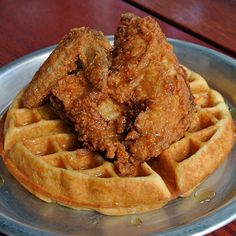 fried chicken and waffles on a metal plate