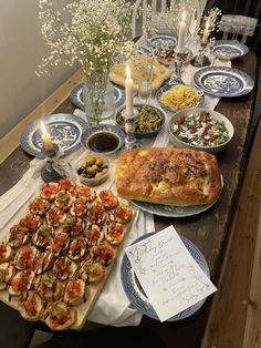 a table filled with lots of food on top of blue and white plated dishes