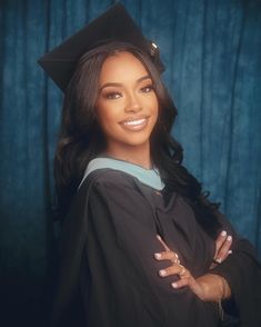 a woman wearing a graduation cap and gown with her arms crossed in front of her chest