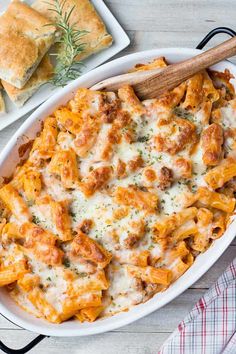 a casserole dish with meat and cheese in it on a white wooden table