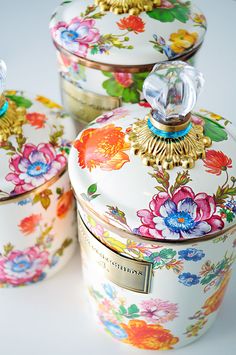 three floral covered dishes sitting on top of a white countertop next to each other