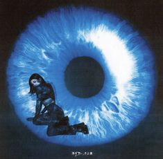 a woman sitting in front of an eyeball with the word blue on it's side