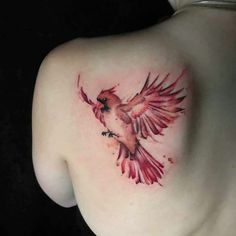 a woman's shoulder with a bird tattoo on the back of her left shoulder