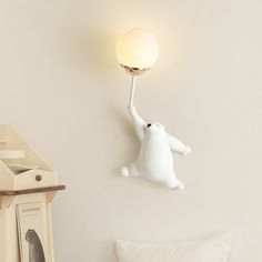 a white polar bear lamp on the wall next to a bed