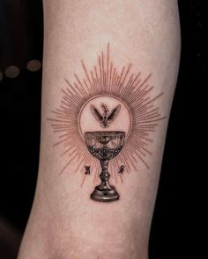 a tattoo on the leg of a person with a cross and sunburst above it