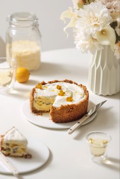 there is a piece of cake on the plate next to some flowers and wine glasses