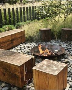 a fire pit surrounded by wooden benches and rocks