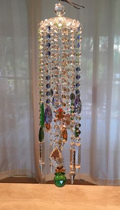 a wind chime hanging from a window with lots of beads and stones on it