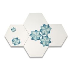 two hexagonal tiles with blue and white designs on the top one has an upside down design