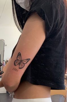 a woman with a small butterfly tattoo on her left arm and lower half of her body