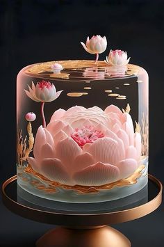 a cake decorated with pink flowers and water lillies on a gold plated stand