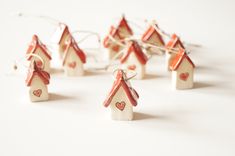 small wooden houses with hearts on them are arranged in a row and tied to strings