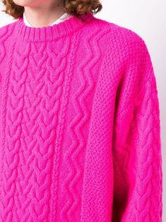 a woman wearing a bright pink sweater