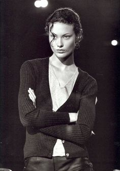 a black and white photo of a woman with her arms crossed in front of her chest