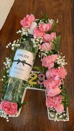 the letter h is made out of flowers and wine bottle with a bow on it