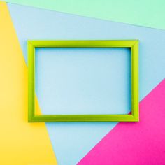 a green frame sitting on top of a multicolored wall next to a yellow and pink square