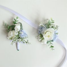 two bridal bouquets with blue and white flowers on the top one is tied to a ribbon