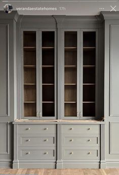 an empty room with gray cabinets and wooden floors