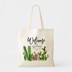 a tote bag with the words welcome in black lettering on it and green cactuses