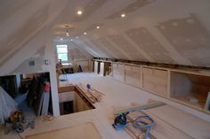 an attic with white walls and unfinished floors