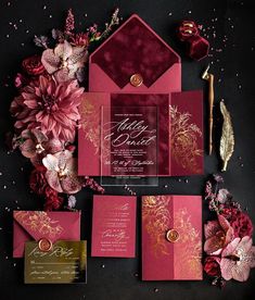 the wedding stationery is red and gold, with pink flowers on each side of the stationery