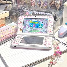 an open laptop computer sitting on top of a desk next to other toys and accessories