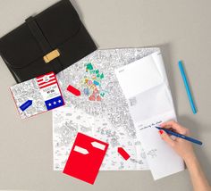 a person writing on a piece of paper next to a notebook and pen with an american flag sticker