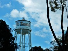 a white water tower with the word bereas on it's side and trees around it