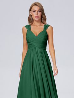 a woman wearing a green bridesmaid dress with straps and pleaed skirt,