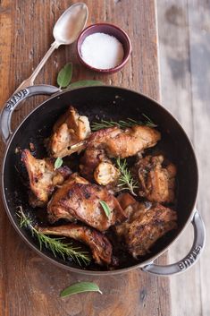 chicken in a pan with herbs and salt