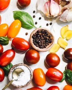 tomatoes, garlic and other vegetables on a white surface